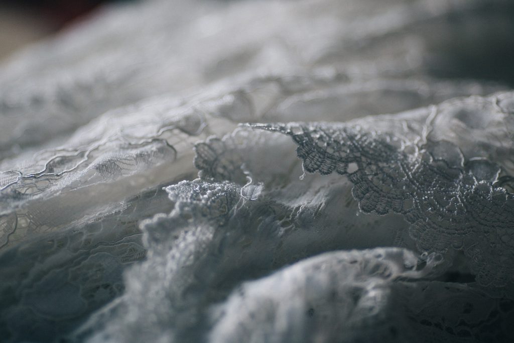 Close-up of premium bridal fabrics including silk tulle and lace used in luxury wedding gowns