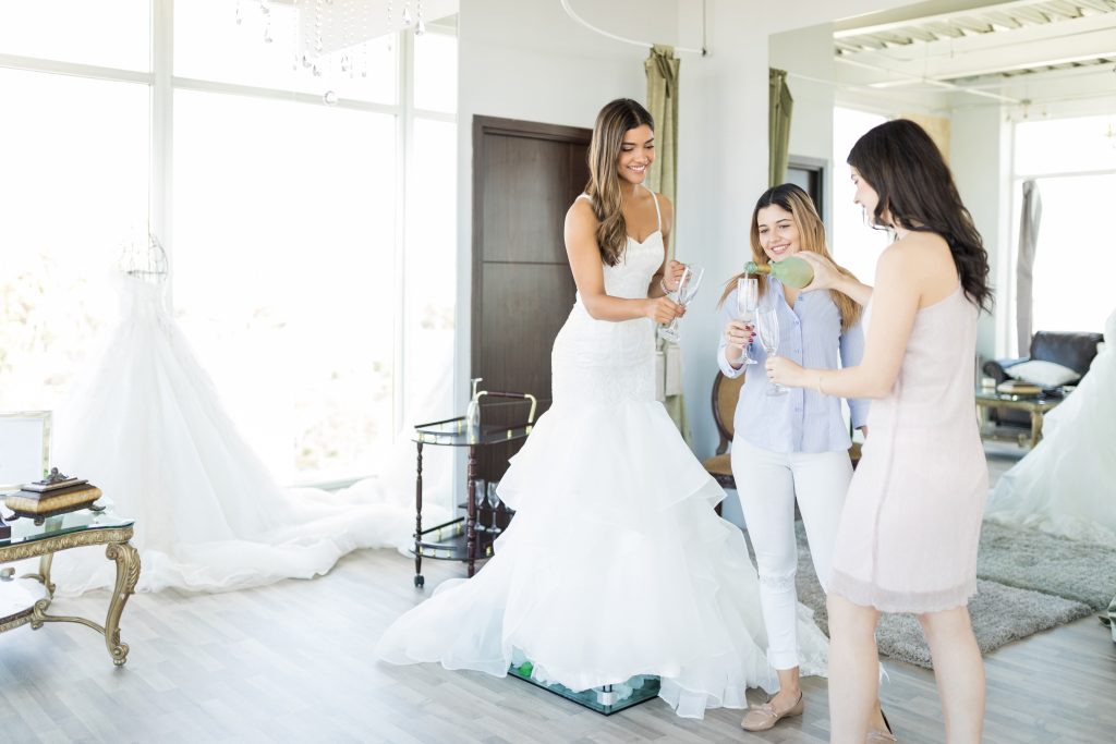 Bride enjoying champagne during a private VIP bridal appointment in an elegant boutique setting