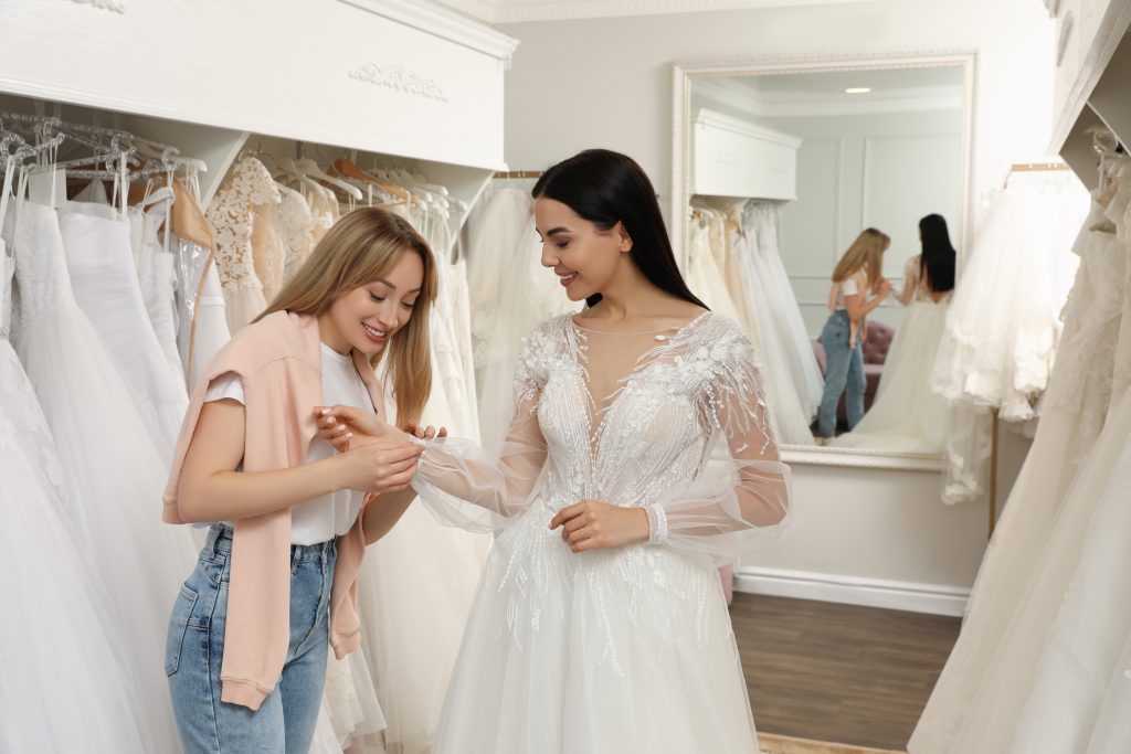 Bride trying on a wedding dress at a boutique while a stylist provides personalized guidance