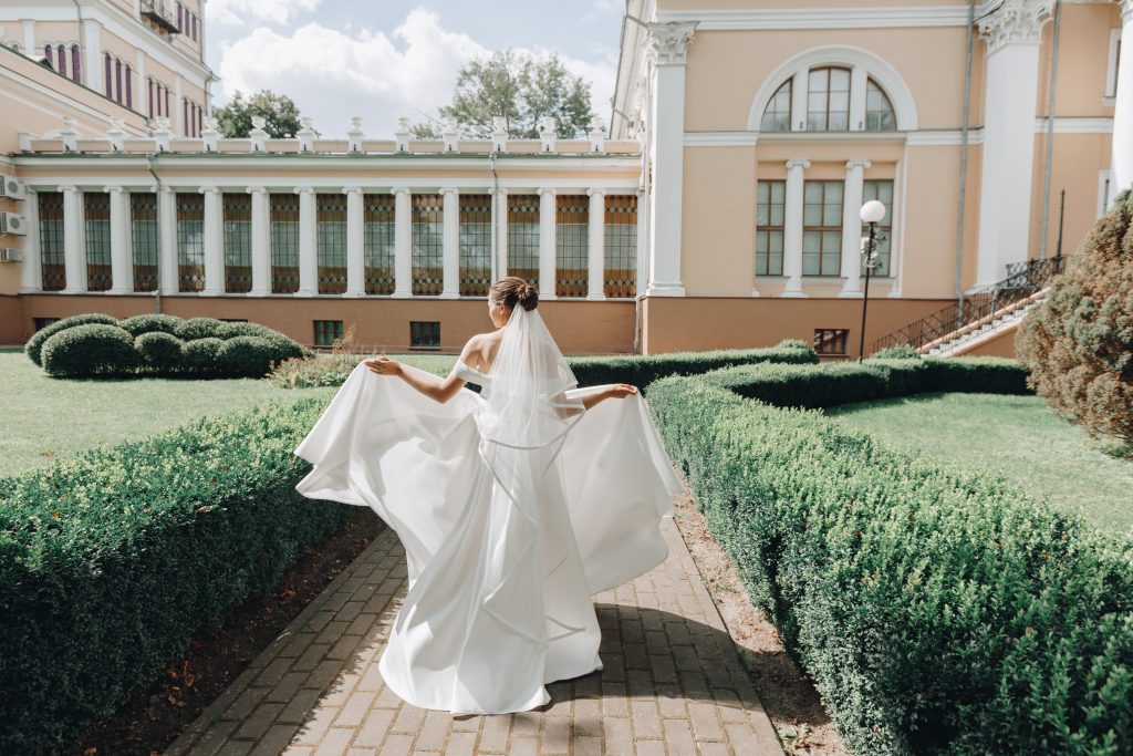 Bride wearing an elegant white gown outdoors in a garden wedding setting
