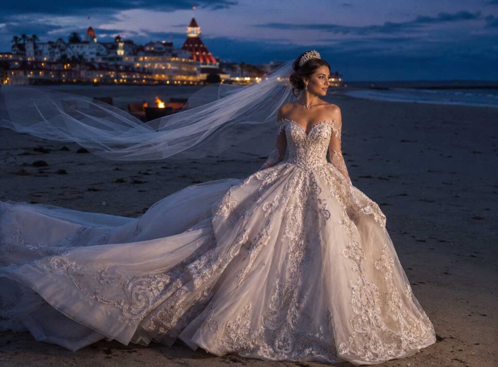 Bride on Coronado Beach at twilight wearing an ornate royal ball gown inspired by vintage and retro wedding dresses.